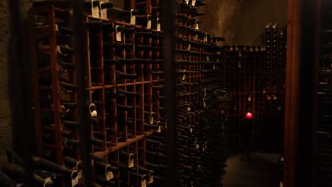 vintage wine bottles stacked in old winery cellar rack for aging