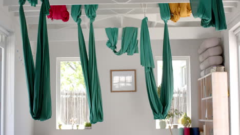 empty white room with hanging gymnastic sashes over plants and wardrobe, slow motion