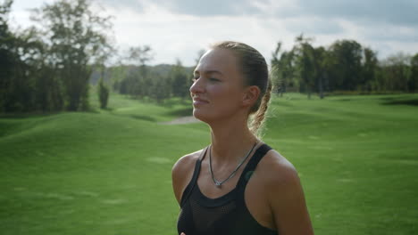 cheerful sportswoman jogging in green field. fit woman running in park