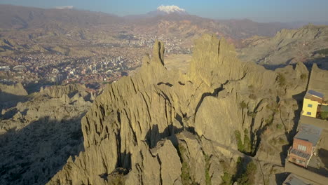 vista aérea épica volando sobre casas ubicadas en una cordillera escarpada para revelar el paisaje escénico de la paz, bolivia