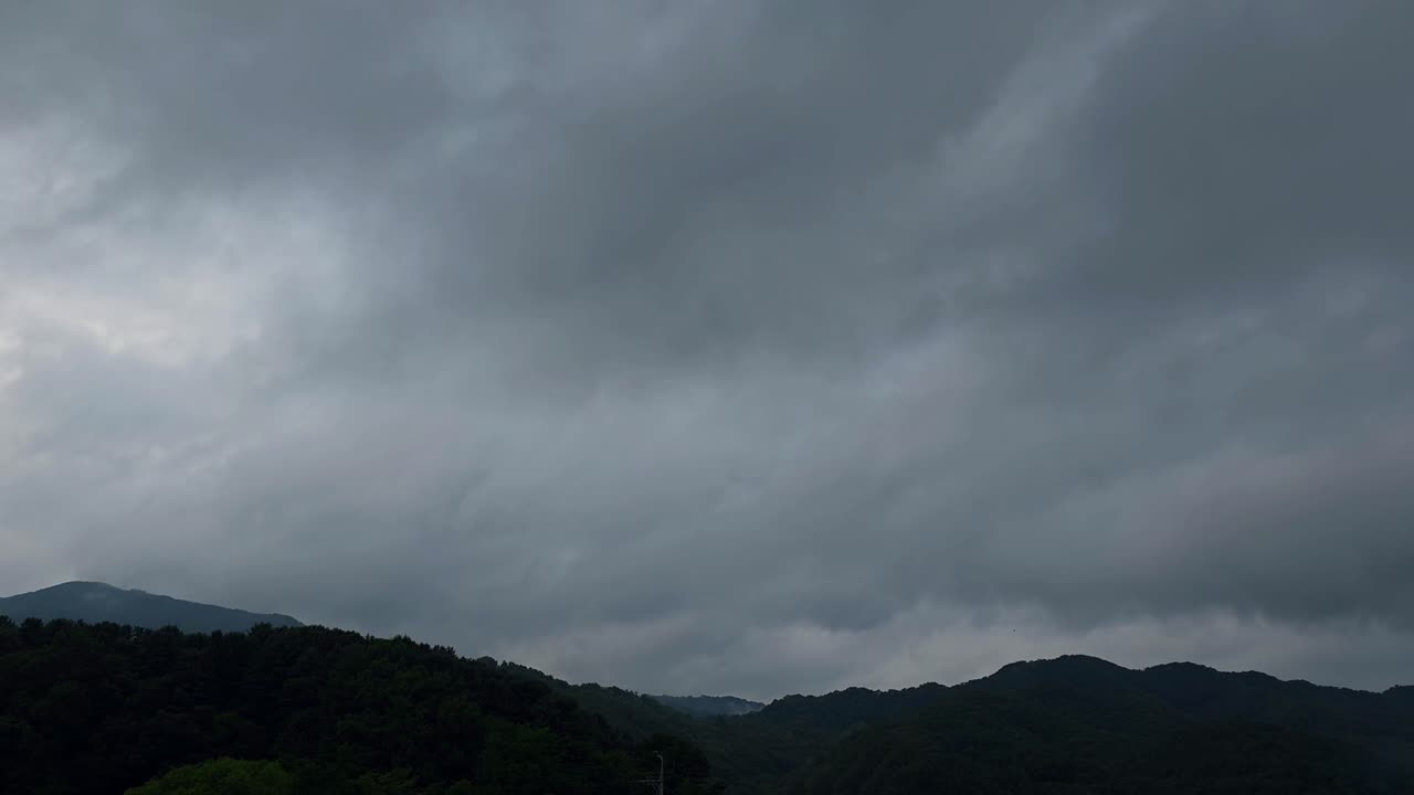 Clouds drifting over Korean mountain landscape in timelapse scene with misty forest hills and changing sky