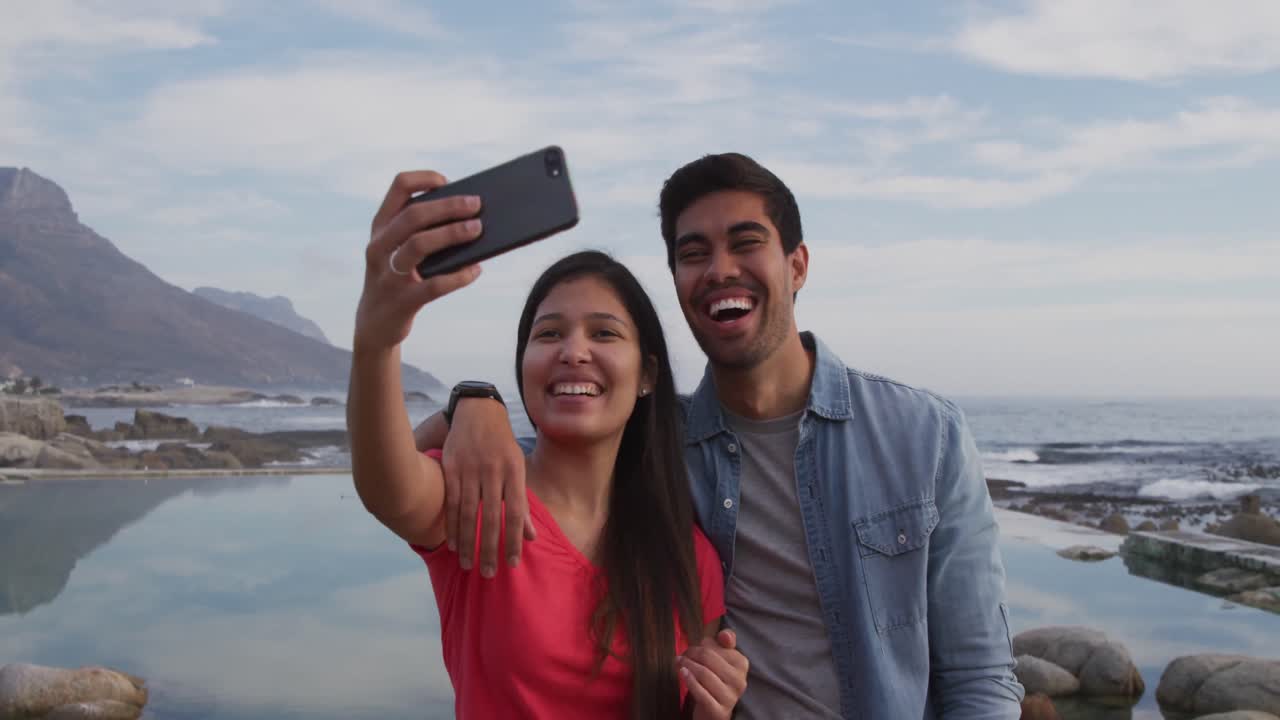 una joven pareja tomando selfies.