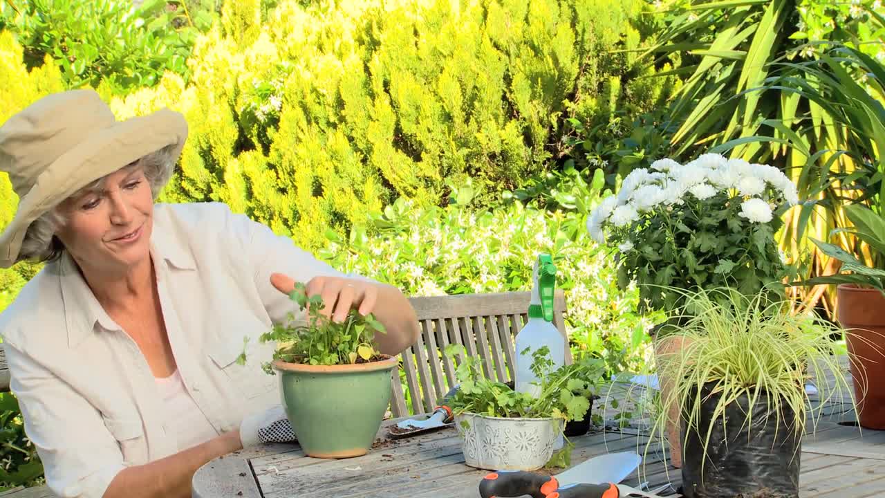 mujer madura sonriendo mientras coloca una planta en la olla