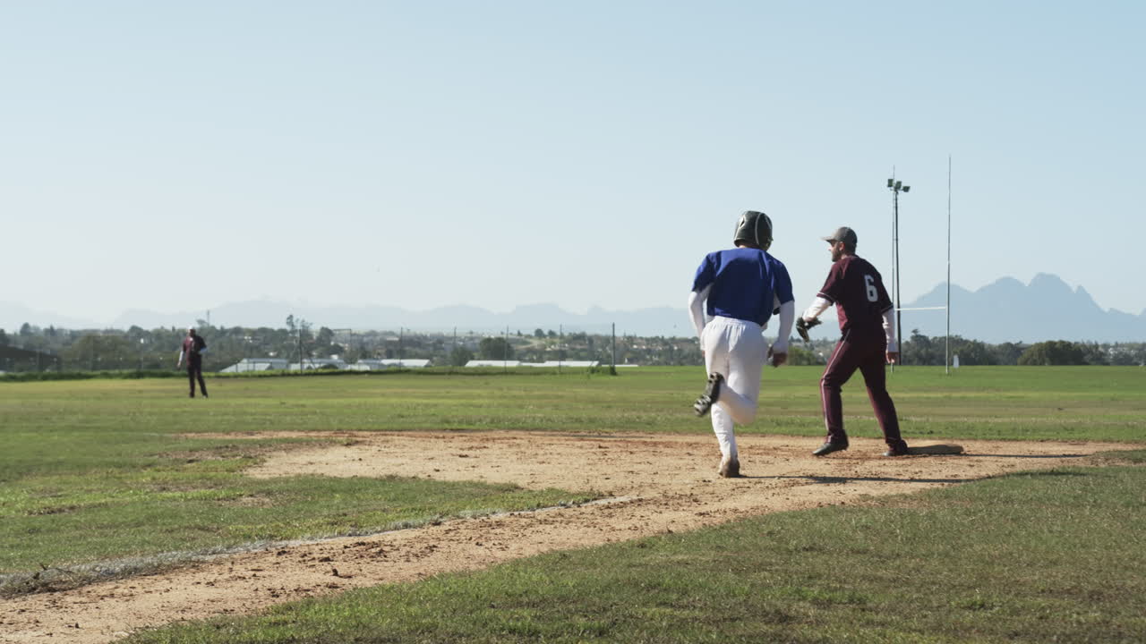Giocatori di baseball maschi multirazziali che giocano a baseball, prendono la palla, corrono su un campo, al rallentatore.