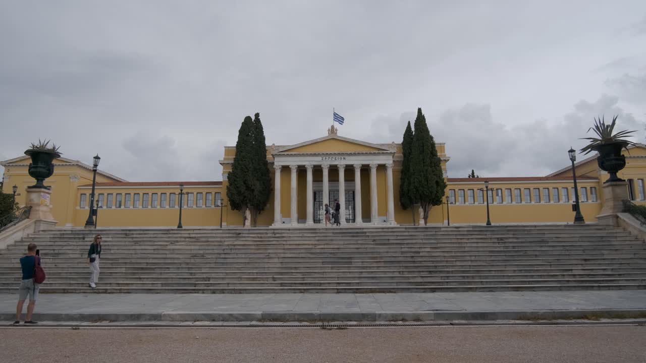 Tourist enjoying their time in front of Academy of Athens, and the National Library of Athens, Greece in a cloudy day on 10-13-2021