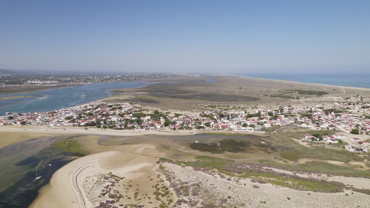 dolly estableciendo aérea de la pequeña ciudad costera de la isla de armona, olhao portugal con playa de arena
