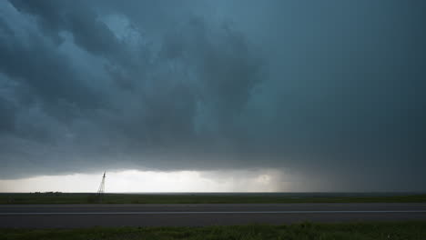car drives by scary powerful stormy sky above