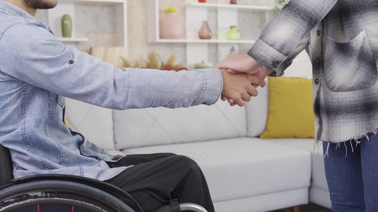 el hombre discapacitado y su amigo se dan la mano, se saludan, apoyan.