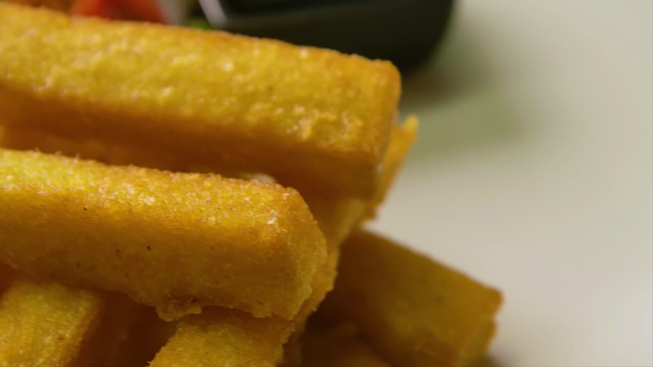 órbita lenta y enfoque rack de plato con patatas fritas polenta, ensalada y lima