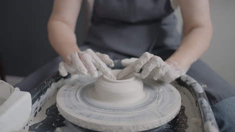 close-up of the hand of a master working on a potter's wheel for the manufacture of clay and ceramic jugs and plates in slow motion