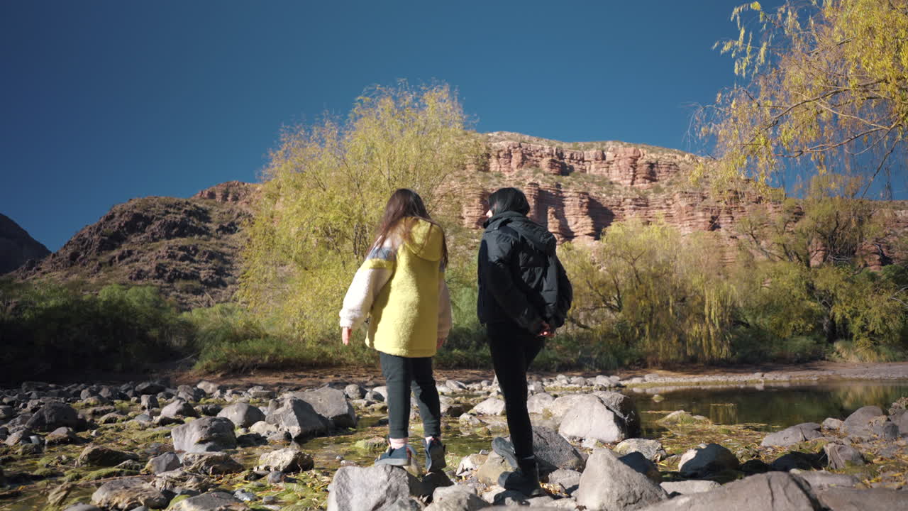 Mother and her daughter seeing around the rocky river landscape at Atuel Canyon, San Rafael, Mendoza, Argentina
