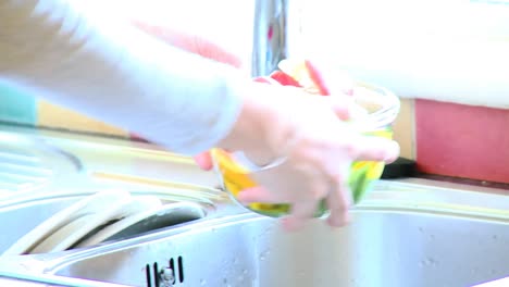 primer plano de una mujer enjuagando verduras