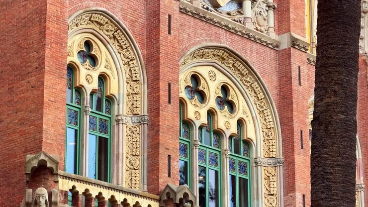 Sculture e finestre Art Nouveau sulla facciata dell'Hospital de Sant Pau a Barcellona, Spagna. Tilt-up.