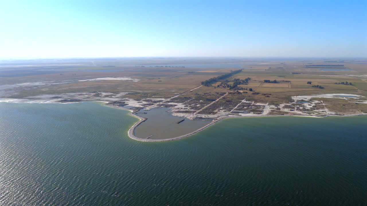 Drone view of Villa Epecuén’s salt-bleached ruins on Lago Epecuén, Buenos Aires Province, Argentina—a haunting reminder of the 1985 flood, drone pulling out,