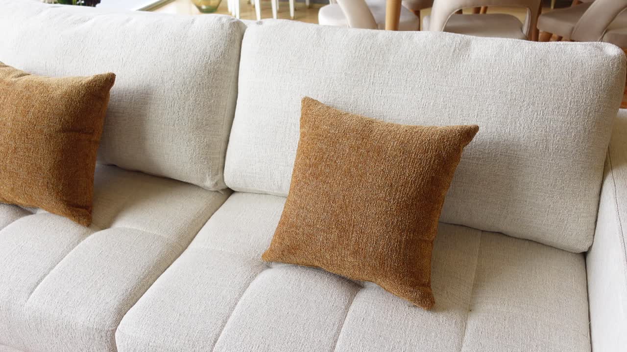 sofá beige con almohadas marrones