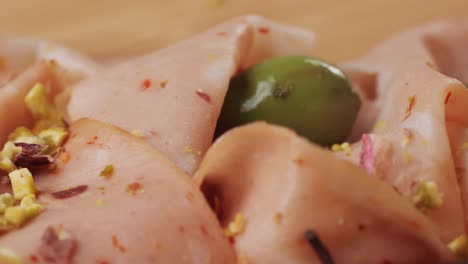 ham italian mordatella, man slices of traditional italian antipasti mortadella sausage on a wooden cutting board, close up macro of chicken or turkey jamon, fat breakfast dish.