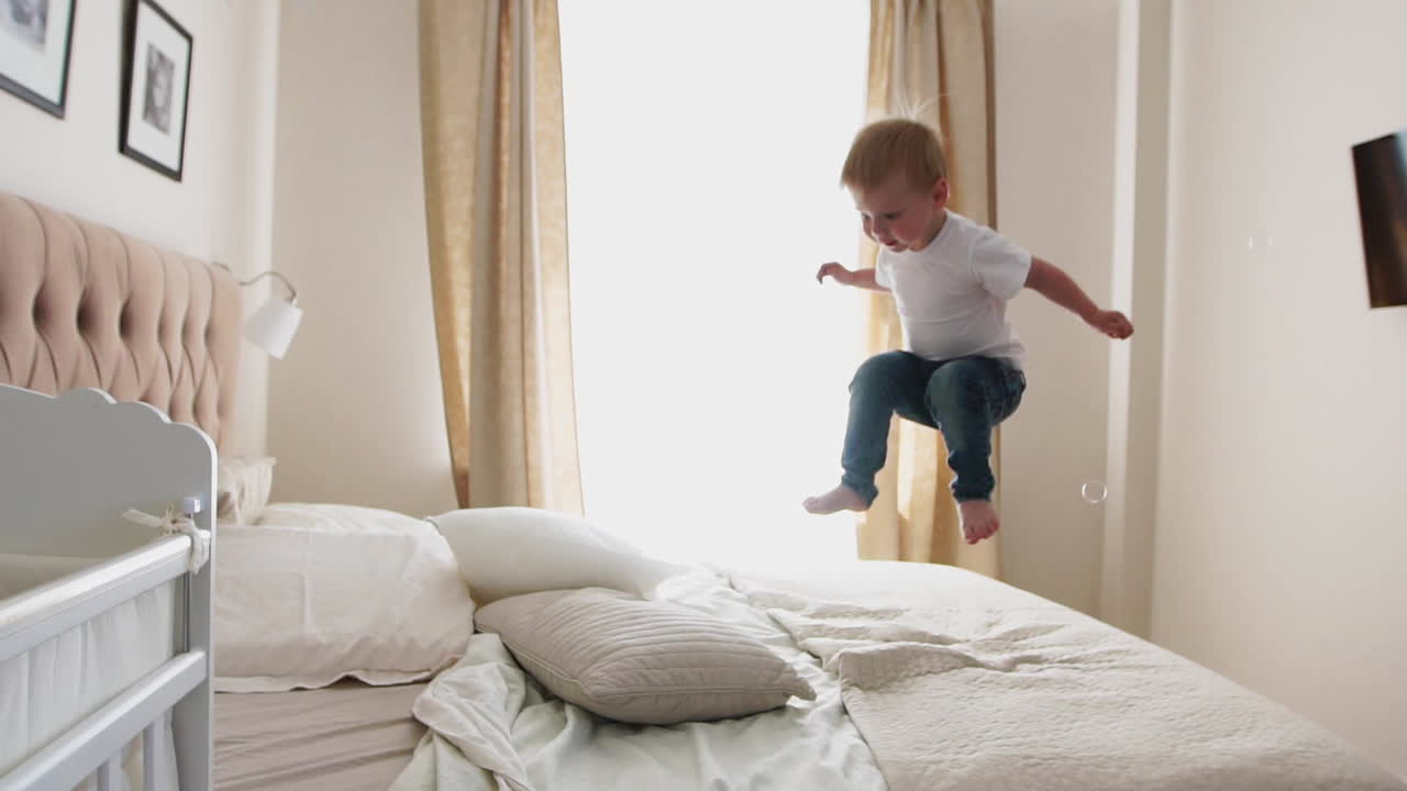 saltando de felicidad en la cama mirando burbujas de jabón volando
