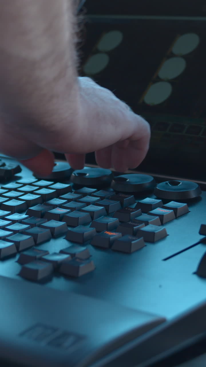 Close-up of Hand Adjusting Knobs on a Professional Control Panel