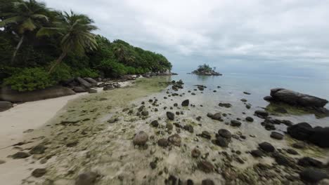 Fpv-drone-flying-on-a-beautiful-beach-in-Seychelles-on-an-Island-Mahe,-video-of-incredible-trees,-Seychelles-rocks,-seaside,-and-surrounding-Seychelles-landscapes