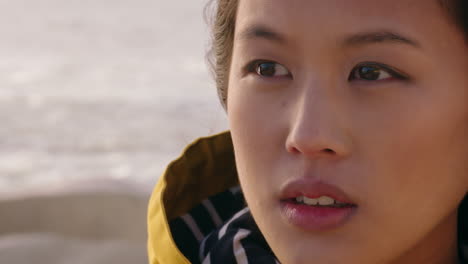 close up portrait beautiful asian woman enjoying freedom exploring wanderlust feeling relaxed on seaside contemplating spirituality at sunset with wind blowing hair