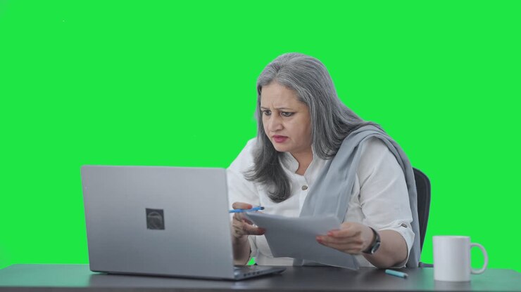 Angry Indian senior female manager doing meeting on video call Green screen