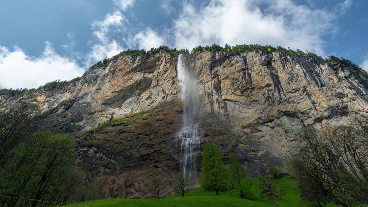 timelapse, cascada y nubes que se mueven por encima de los acantilados de los alpes suizos, pueblo de lauterbrunnen
