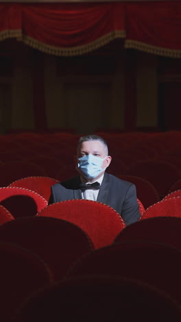 man wearing mask in theater
