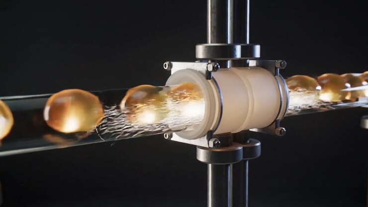 Motor activating in lab pushing amber capsules through tube coupling to transfer, emitting trails