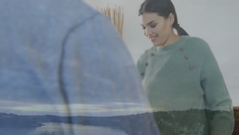 Wearing green sweater, woman with animation of scenic landscape overlay