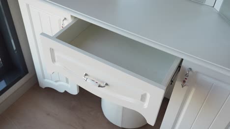 open drawer of a white dressing table