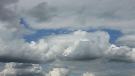 capas pictóricas lentas y dramáticas de formaciones de nubes cúmulos que surgen y están oscurecidas por una manta contra un cielo azul
