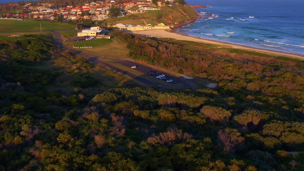 vista aérea de un aparcamiento en la playa de wollongong al atardecer - nsw, australia