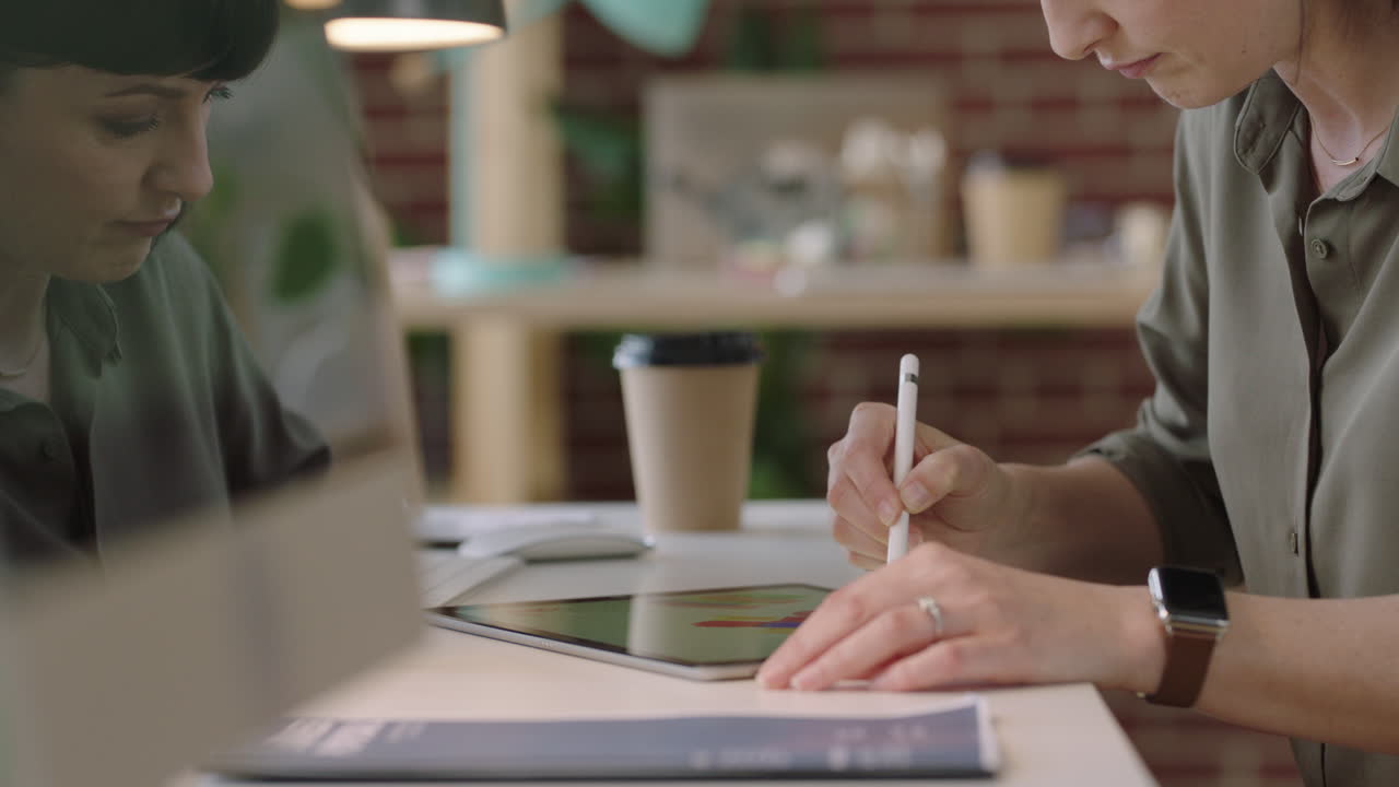 joven diseñadora gráfica de negocios que usa una tableta, dibuja en un dispositivo de pantalla táctil, hace una lluvia de ideas de diseños creativos para un proyecto corporativo