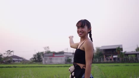 woman stretching and enjoying the sunset in a lush green rice field