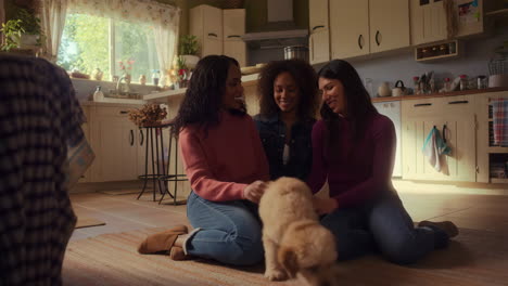 three women playing with a golden retriever puppy in a kitchen