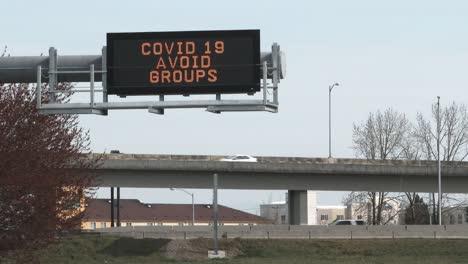 traffic on highway and covid 19 avoid groups sign