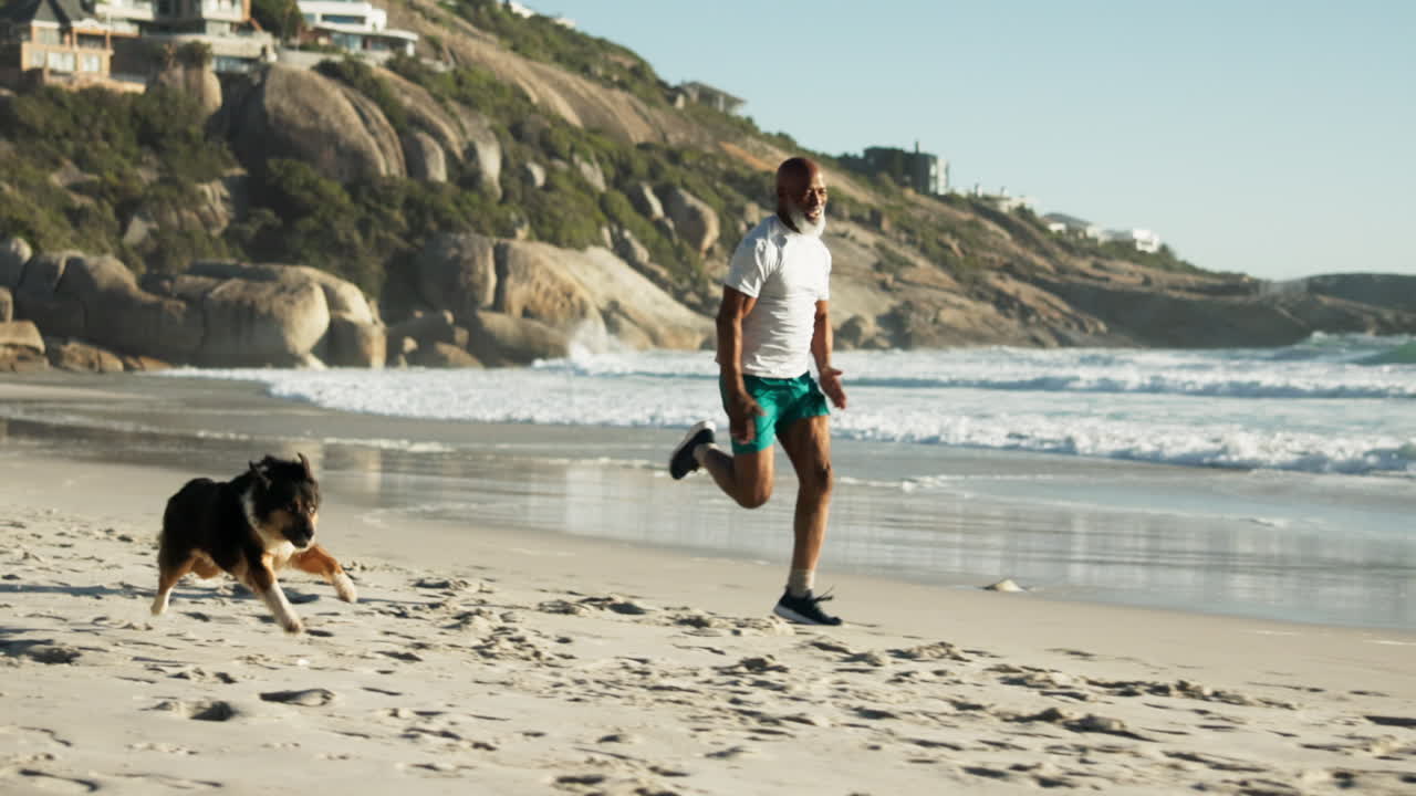 Man and dog running on the beach