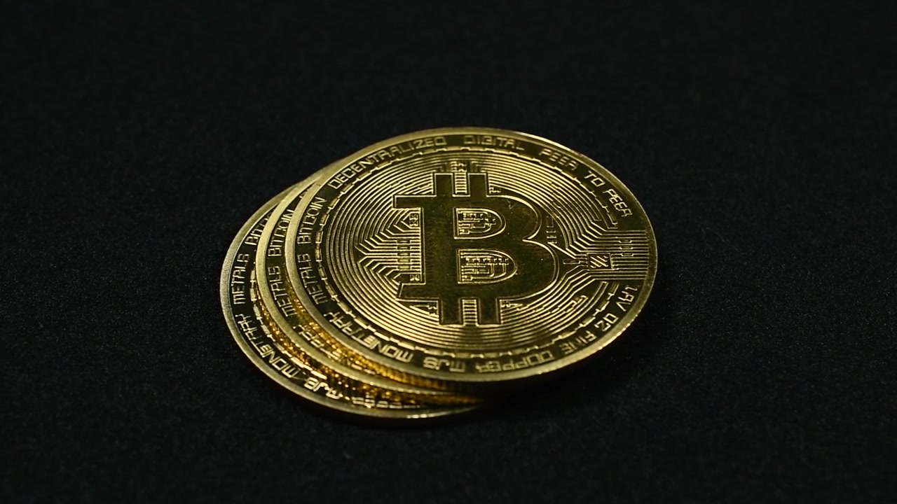 Passando Accanto a Bitcoin Dorati su Sfondo Nero