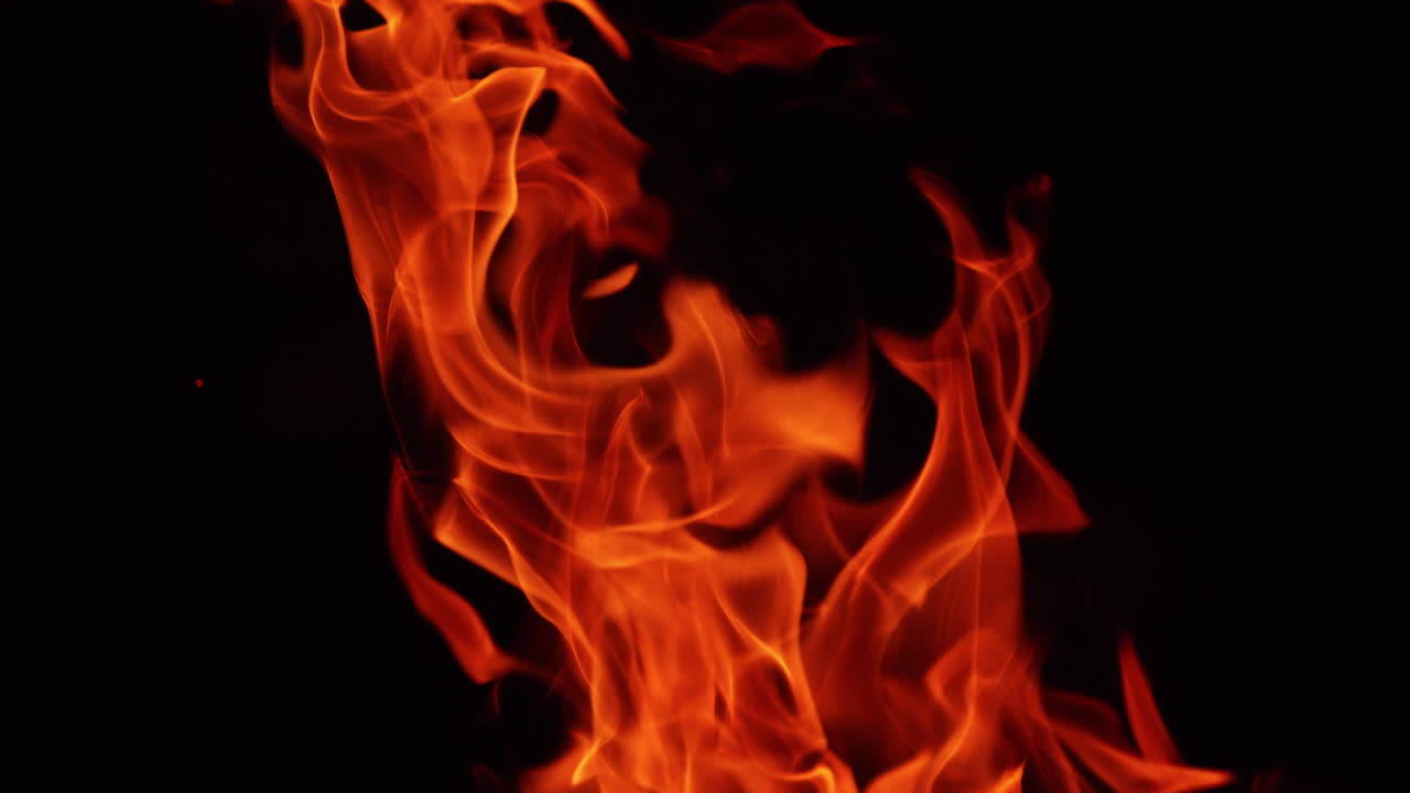 Burning fire on black background. Hot red flames moving in darkness. Close up.