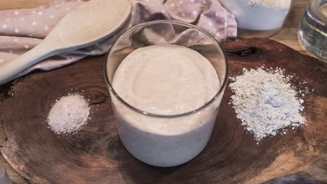 Timelapse-Of-Sourdough-Starter-Yeast-Rising-And-Bubbling-In-An-Open-Jar---high-angle,-zoom-in