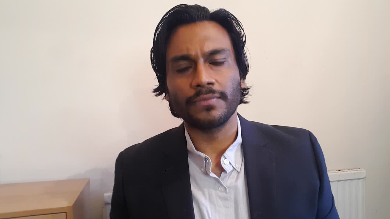 Young Man On Business Video Call Listening Intently Whilst Looking Directly to Camera