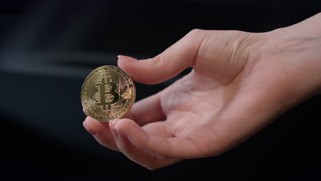 Woman-hand-holding-gold-bitcoin-coin.-Bitcoin-business-concept.-Bitcoin-in-hand