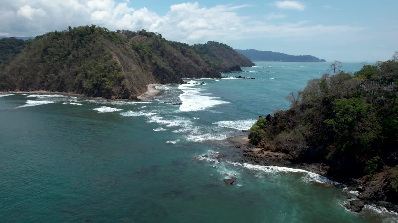 Waves crashing between coastline and island in Costa Rica
