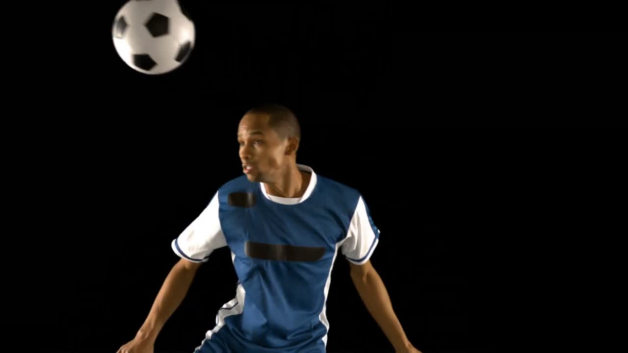 공을 헤딩하는 축구 선수