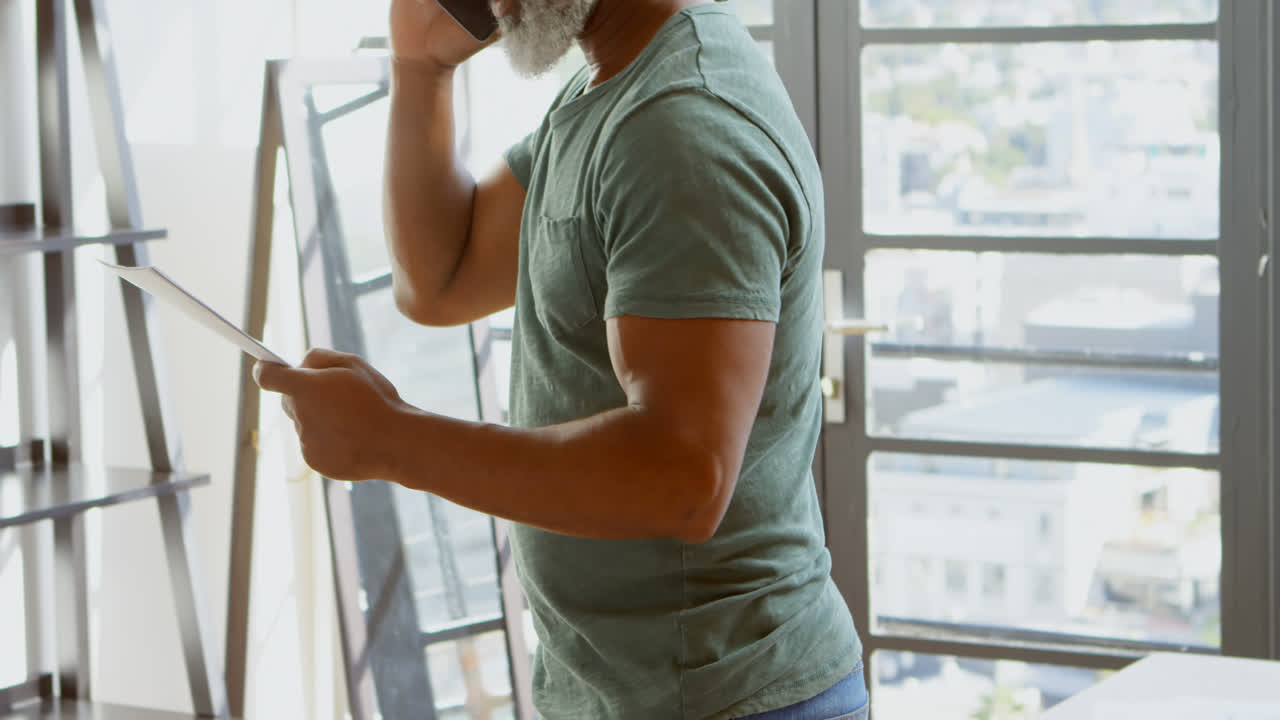 Uomo anziano che parla al cellulare a casa 4k