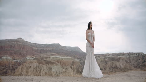 novia en un impresionante vestido de novia en medio de las montañas de capadocia