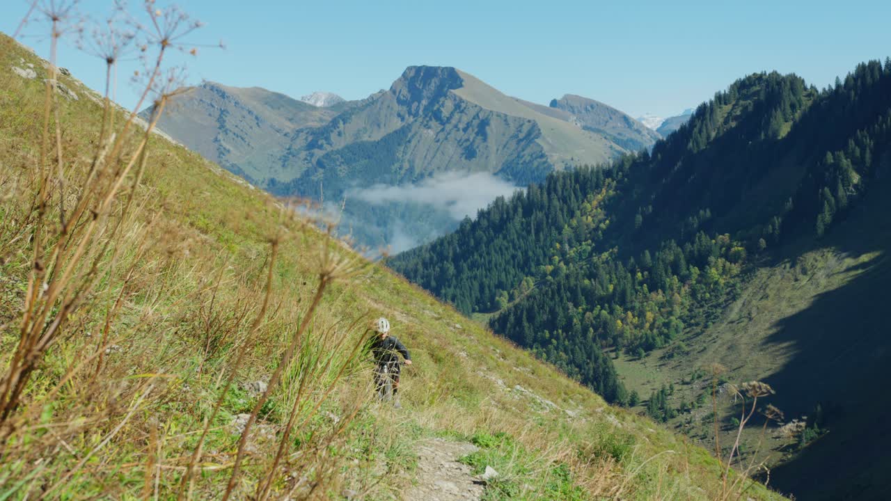un ciclista de montaña pedalea por un sendero alpino en otoño