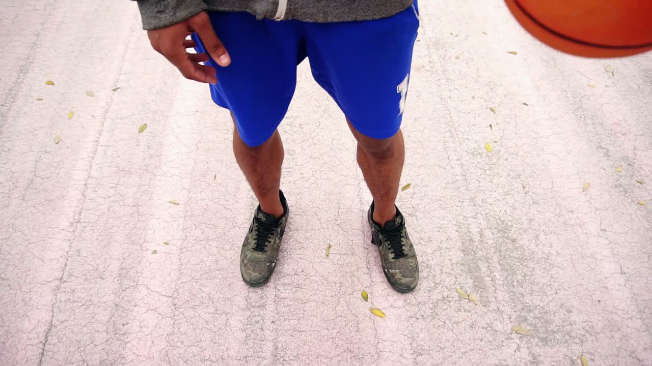 Close Up view of unrecognizable african american man practicing basketball outside. View from the top. Slow Motion shot