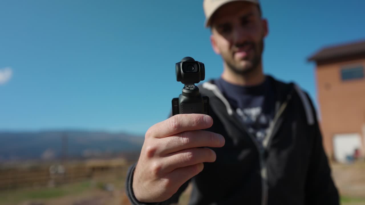 Dji Pocket 3 flagslip gimbal camera, man showing to camera, vlogging, outdoor