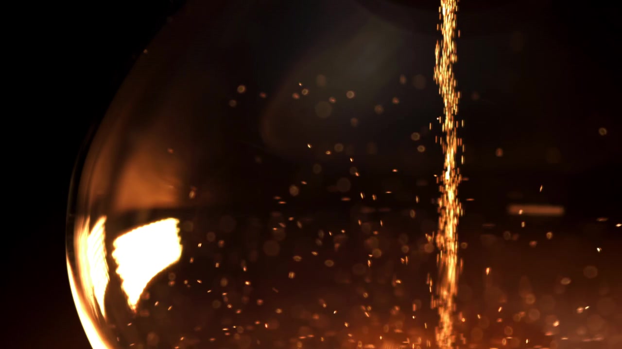 Sparkling Golden Sand Falling in an Hourglass on a Dark Background
